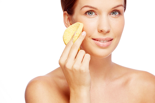 Girl cleans the skin cream with a sponge