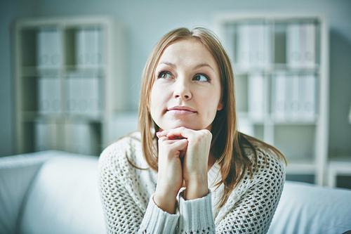 Pensive woman sitting at home