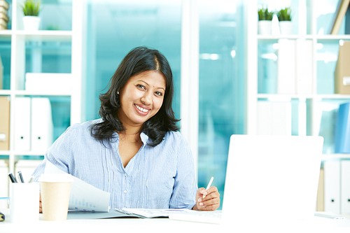 Cheerful businesswoman  while sitting at workplace