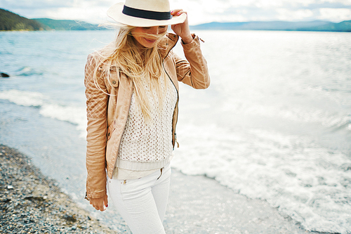 Happy long-haired girl walking along sea shore