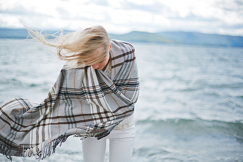 Young woman covered with blanket at the beach