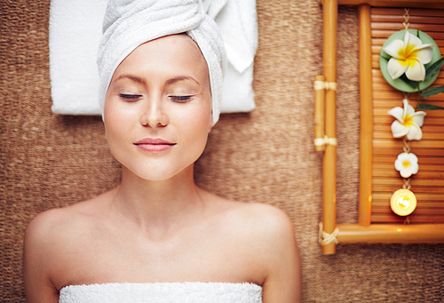 Young woman with closed eyes relaxing in beauty salon