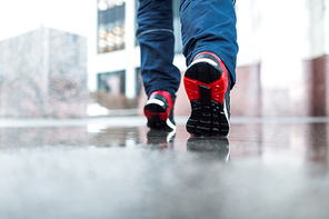 Legs of energetic sprinter jogging down marble surface