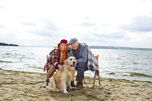 Seniors stroking dog and enjoying autumn weather