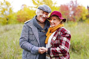 Positive loving senior couple posing for camera