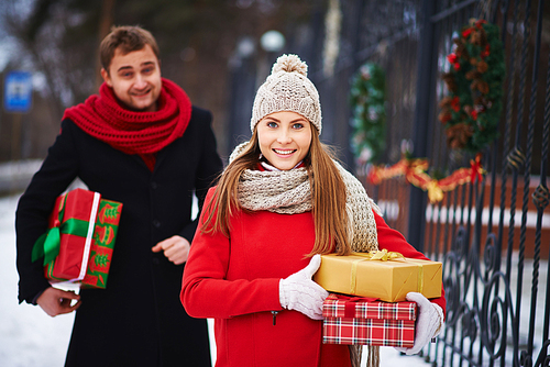 Cute girl with giftboxes  on background of young man