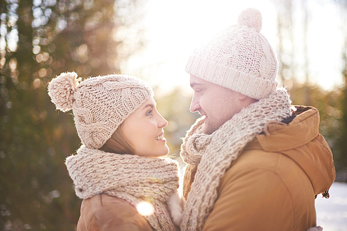 Happy young man and woman looking at one another on winter day