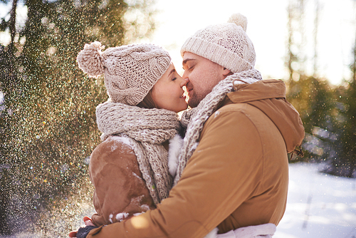 Amorous man and woman kissing on winter day