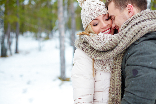 Happy girl and her boyfriend in winter park