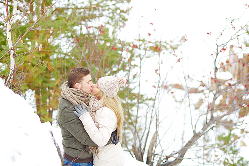 Young couple kissing in winter park