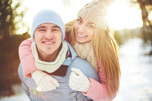 Happy guy and girl in winterwear having fun outside