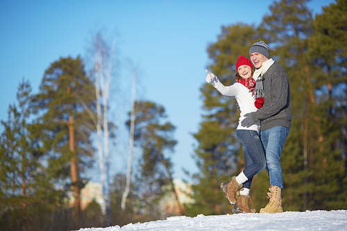 Ecstatic young couple in winterwear spending leisure in park