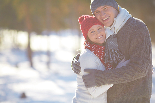 Embracing couple in casual winterwear  outdoors