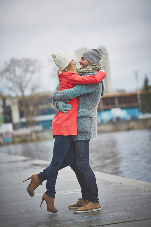 Happy amorous couple embracing in urban environment