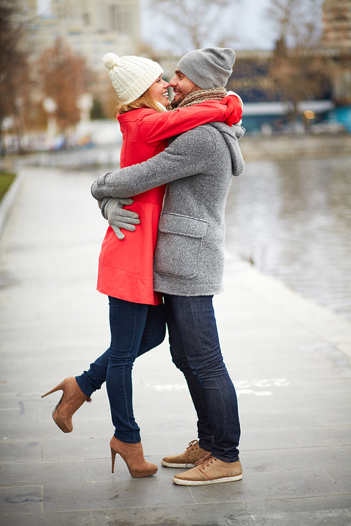 happy guy and his girlfriend embracing in urban
