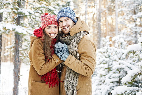 Embracing couple  with smiles in winter park