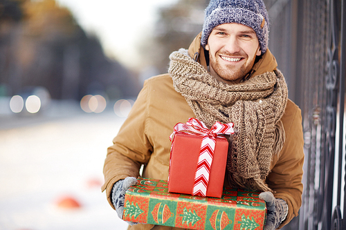 Young man with Christmas gifts  outside