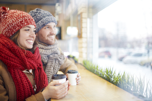 Romantic dates in winter-wear having drink in cafe