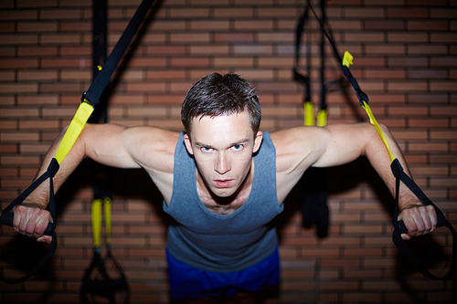 Young man working out in gym on sport equipment