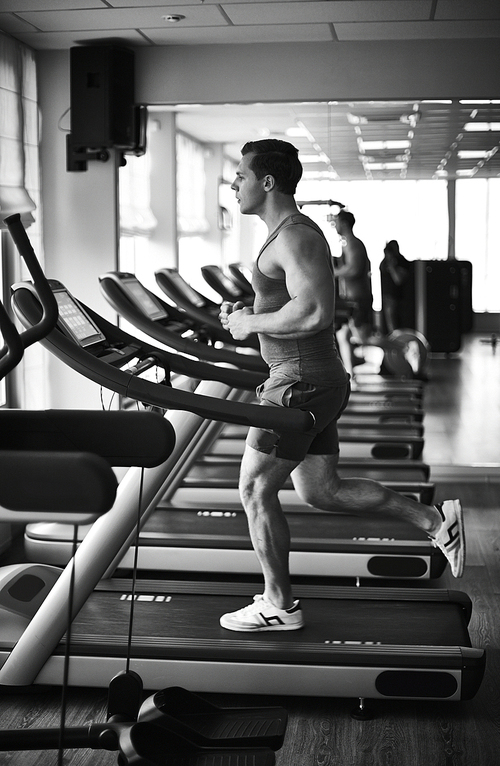 Young man training on sport facilities in gym