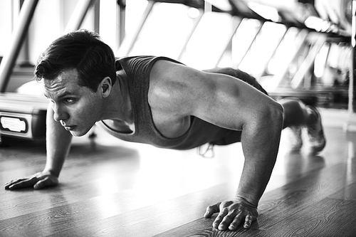 Handsome man doing physical exercise on the floor