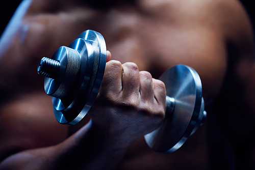 Young athlete holding barbell during exercise