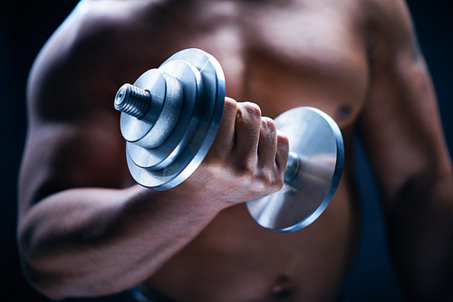 Young man with barbell exercising in gym