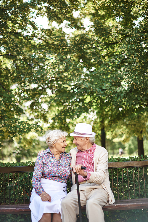 Happy seniors relaxing on bench in park