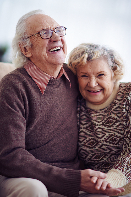 Joyful elderly man and woman in sweaters