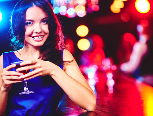Happy young woman with glass of martini 