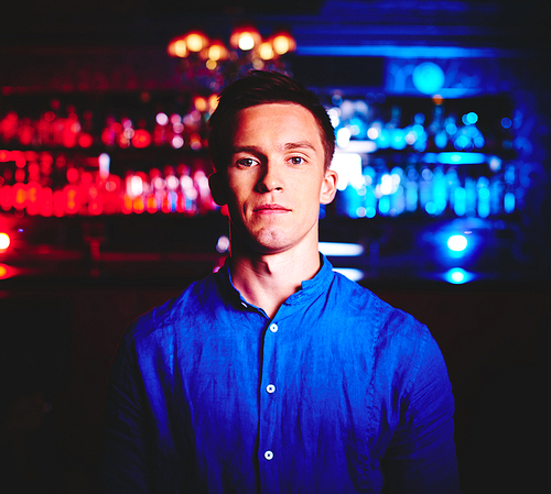 Young man in blue shirt  in night club
