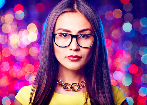 Young Asian woman in eyeglasses  on sparkling background