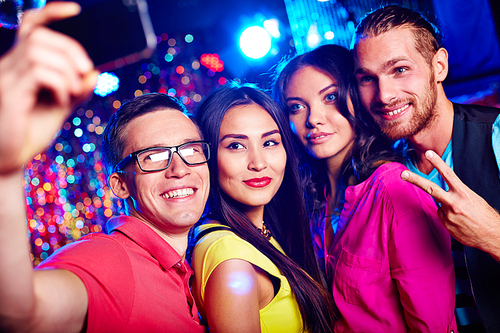 Young friends making selfie during party in nightclub