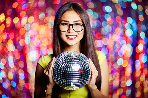 Posh girl with disco ball  in club
