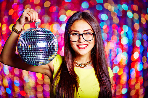 Pretty girl with toothy smile holding disco ball and 