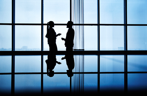 Two people communicating in dark office