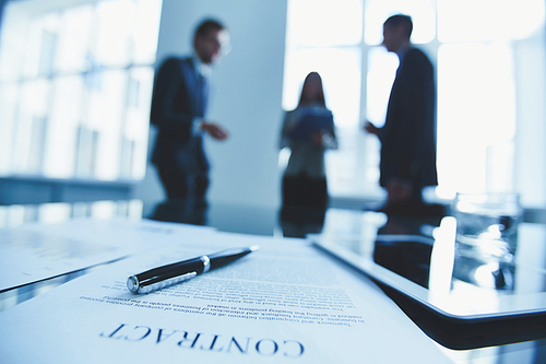 Close-up of contract with business people in the background