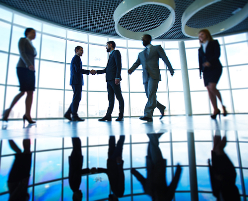 Modern business people against window in office building