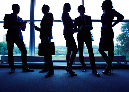 Group of employees having business meeting against window