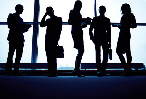 Several business partners having meeting by office window