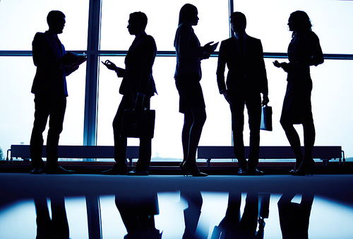 Several employees communicating by office window