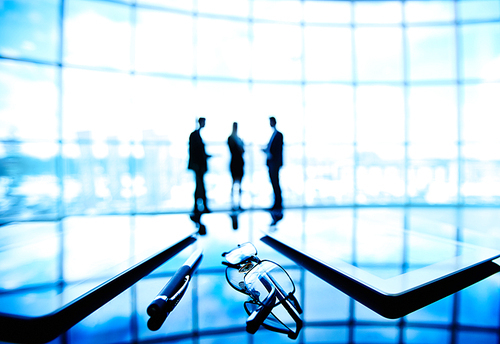 Touchpads and glasses on table in boardroom