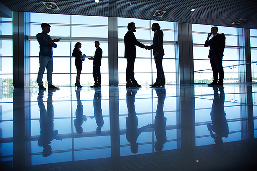 Several office workers standing by the window