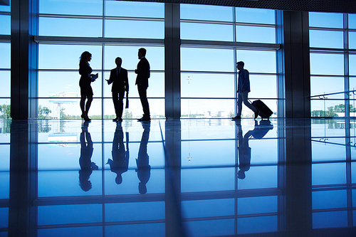 Several office workers talking by the window inside modern office building