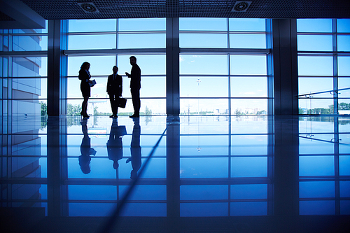 Three business people in dark corridor