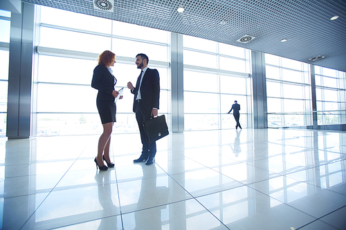 Two colleagues talking in office building