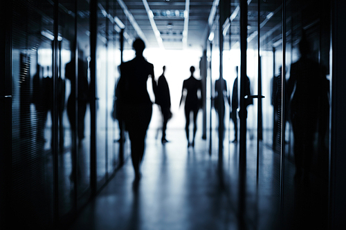 Silhouettes of several business people in corridor of office building