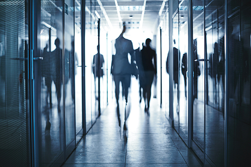 Blurred silhouettes of business people walking to their offices