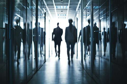 Several business people walking inside office building