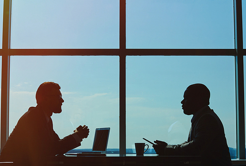 Outlines of two businessmen having meeting